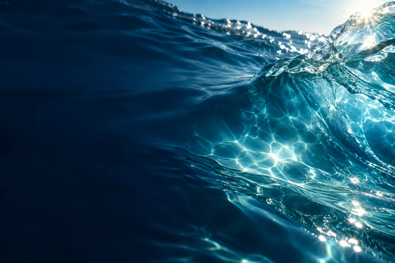 Sunlight moving through a clear blue water ripple